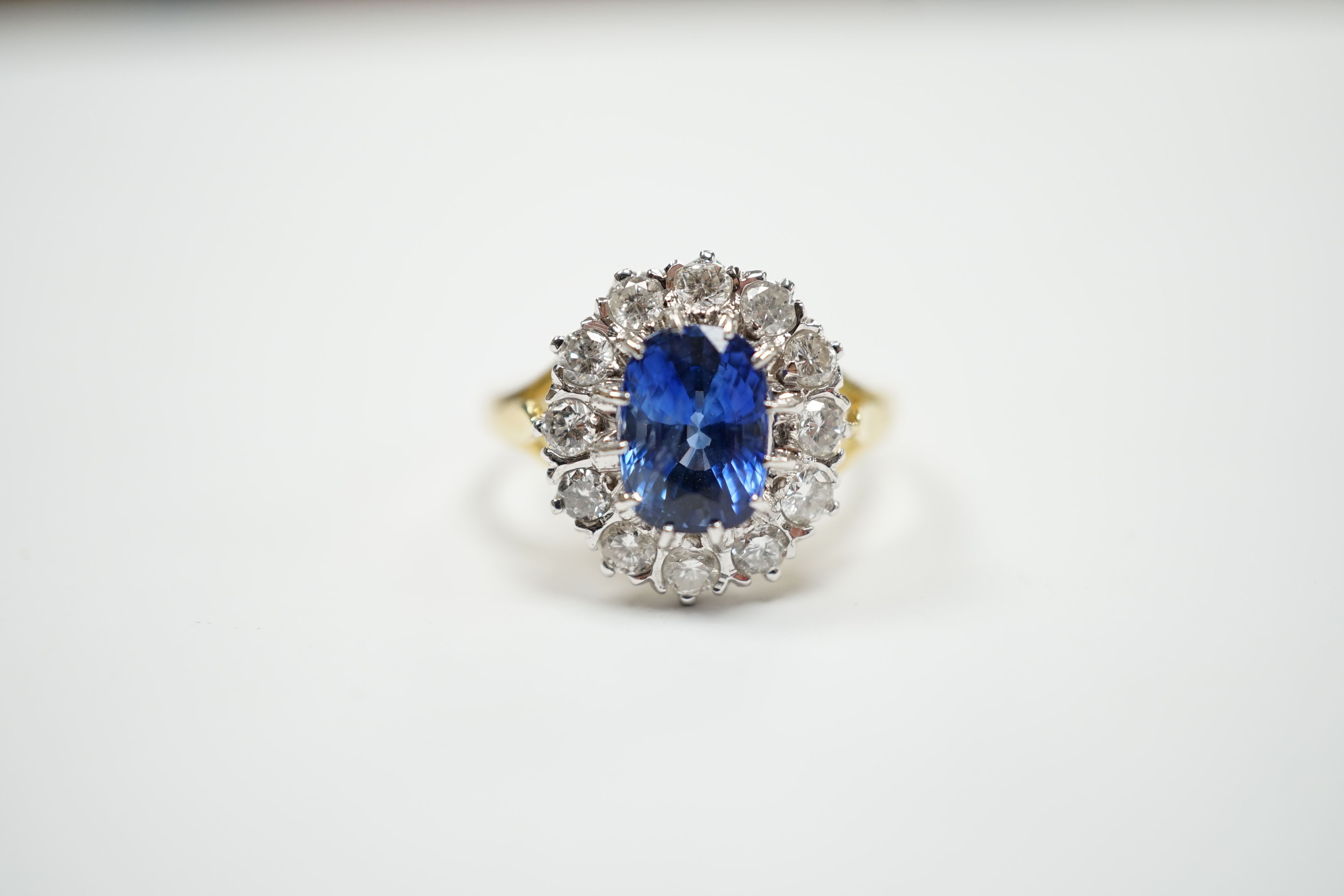 A modern 18ct gold, sapphire and diamond set oval cluster ring, size O, gross weight 5.6 grams.